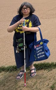 Photo of Connie Bateman wearing Blind Girl Designs t-shirt and tote bag, St. Louis, July 2026